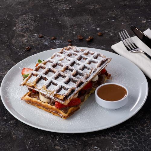 Waffle with fresh strawberry, banana and milk chocolate sauce